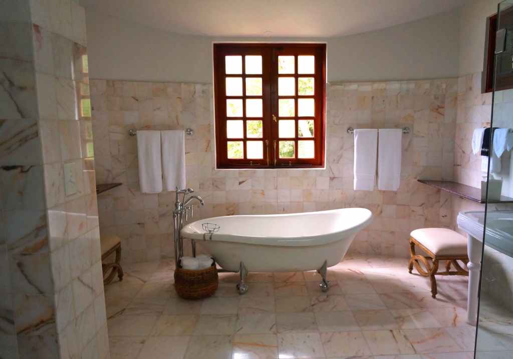 Old fahioned bathtub in a marble tiled room